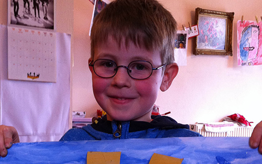 boy holding up painting