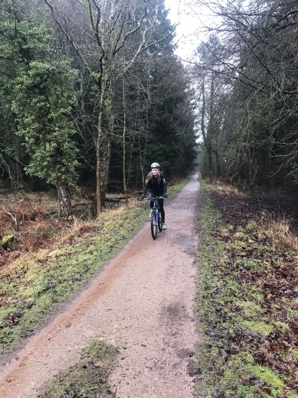 girl riding a bike through the woods