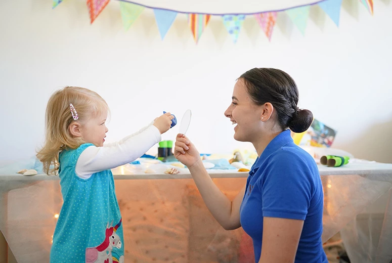 Norland student and little girl playing in nursery