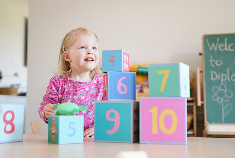 young girl playing with numbered boxes