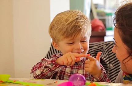 child and female nanny doing arts and crafts