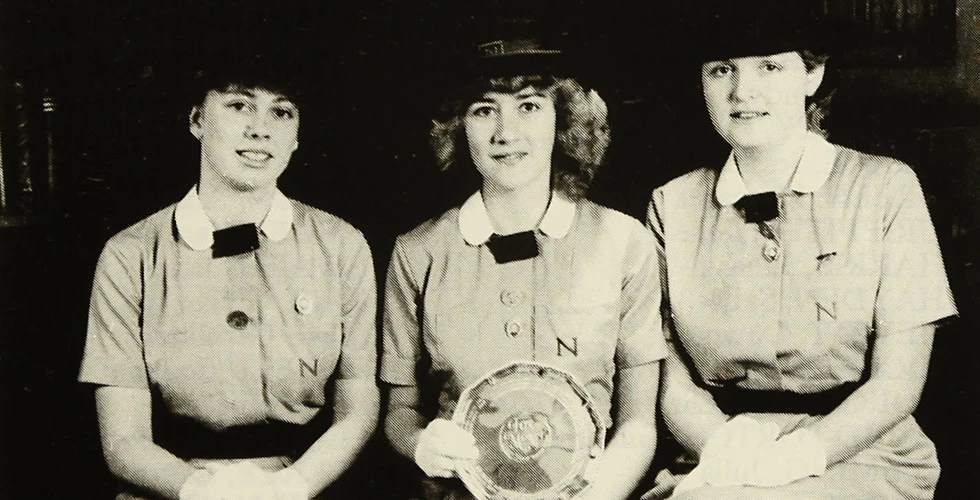 three Norland nannies in uniform holding plate 1986