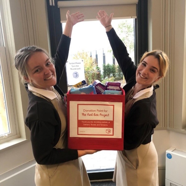 2 girls holding a box of donations