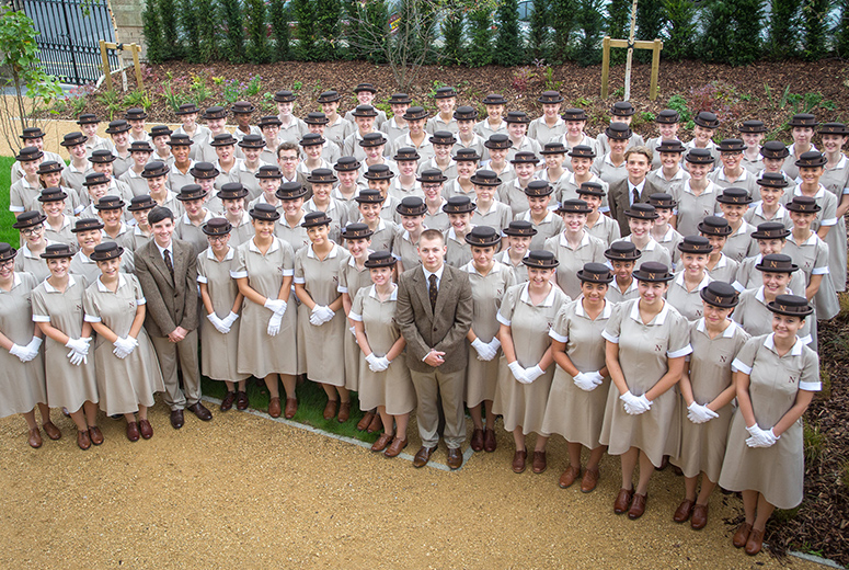 large group of Norland nannies in uniform standing for photograph