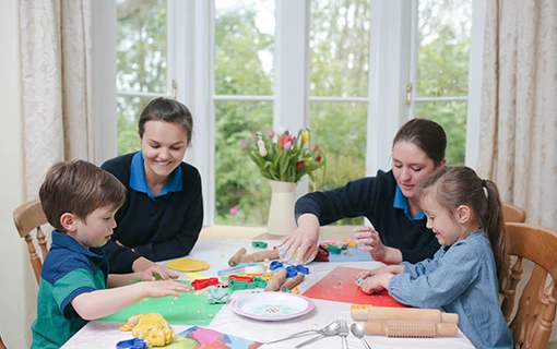 2 children doing arts and crafts with Norland nannies