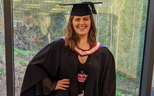 a female student smiling in her graduation robes