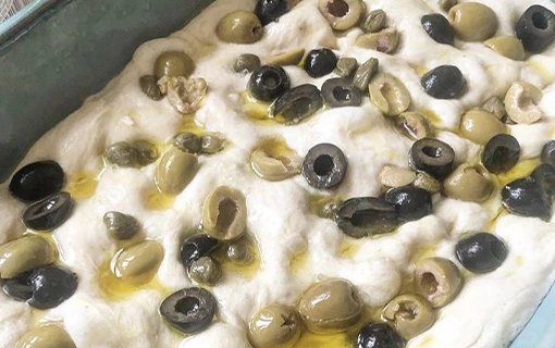 a tray with sourdough focaccia mixture about to go into the oven