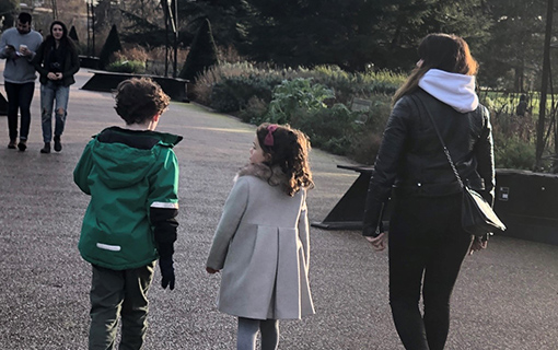 two children and a lady walking down a path