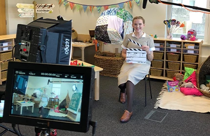 a female in uniform on a film set with a clapper board