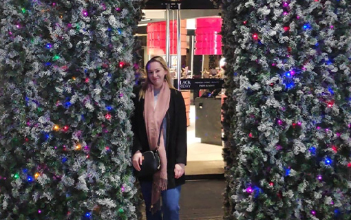 a female student stood in a flower arch