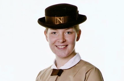 a female student in her formal uniform smiling