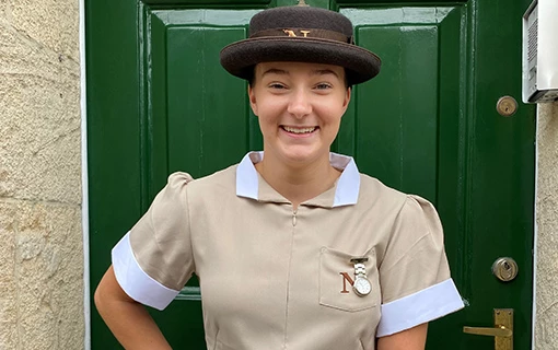 a female student in her formal uniform smiling