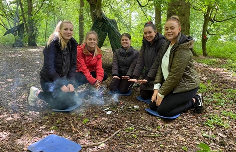 five females sat around a campfire