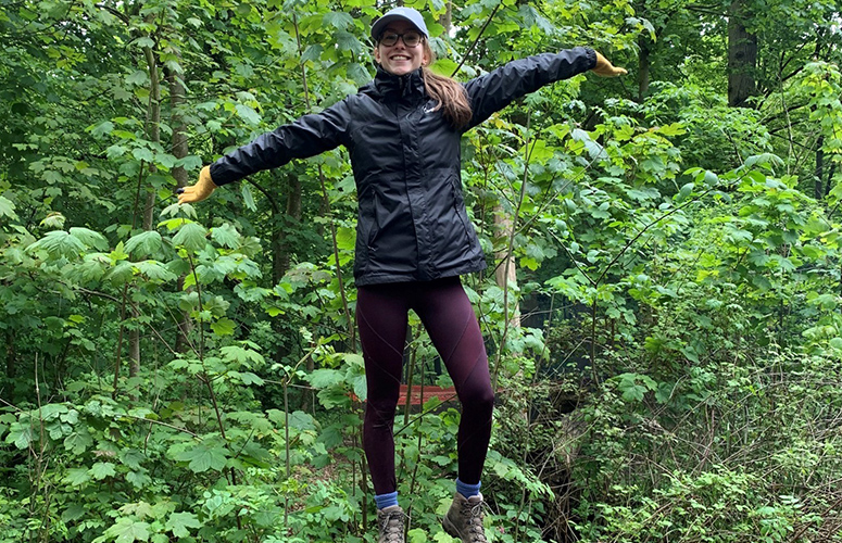 a female stood on a tree trunk smiling