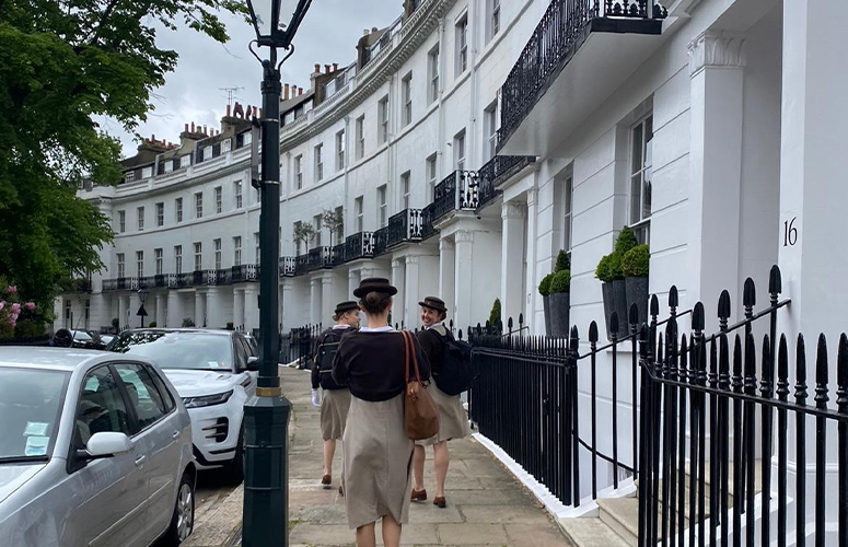 A group of Norland students in their uniform walking along a street in London