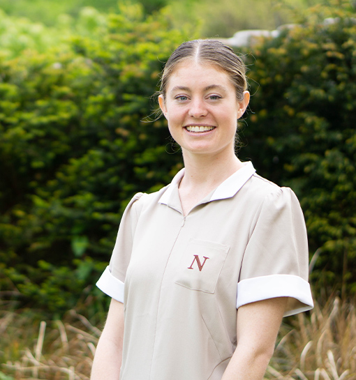 a female international norland student who is studying an early years degree in her uniform smiling