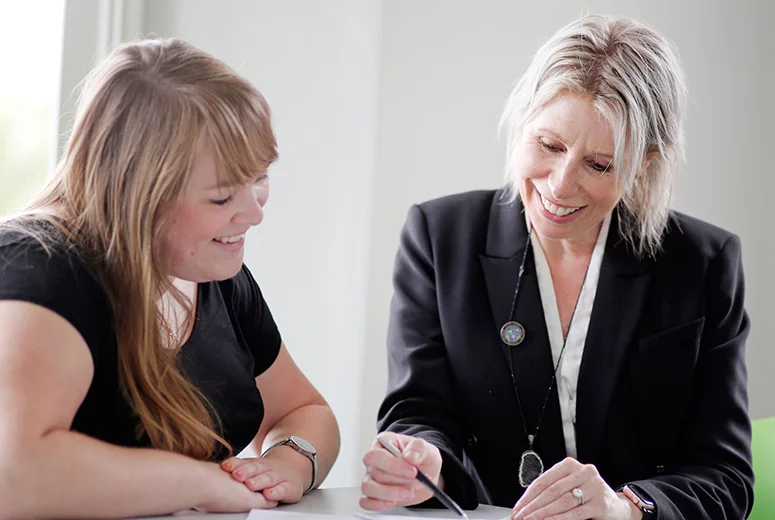 two ladies looking at a piece of paper