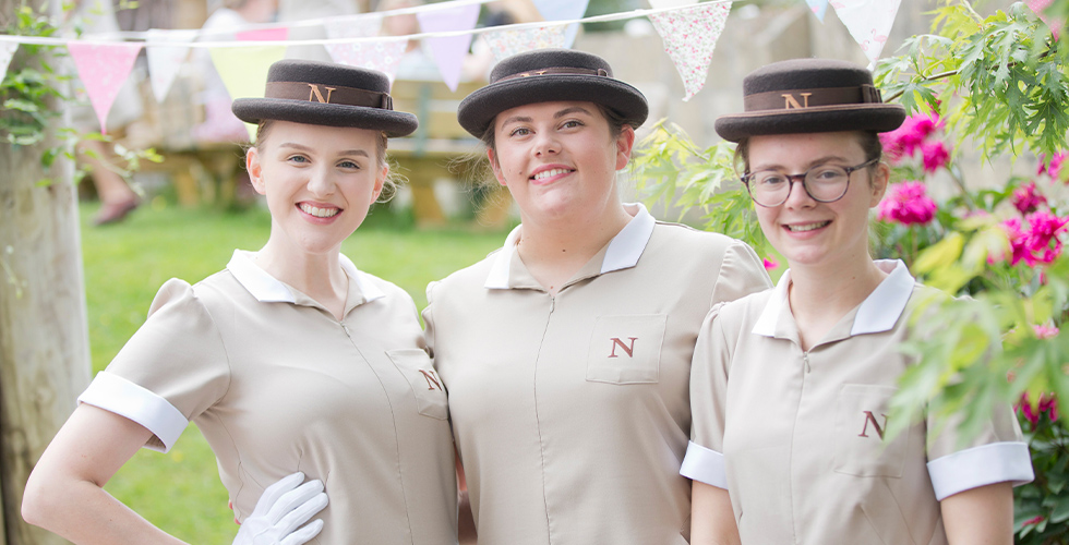 three students smiling outside