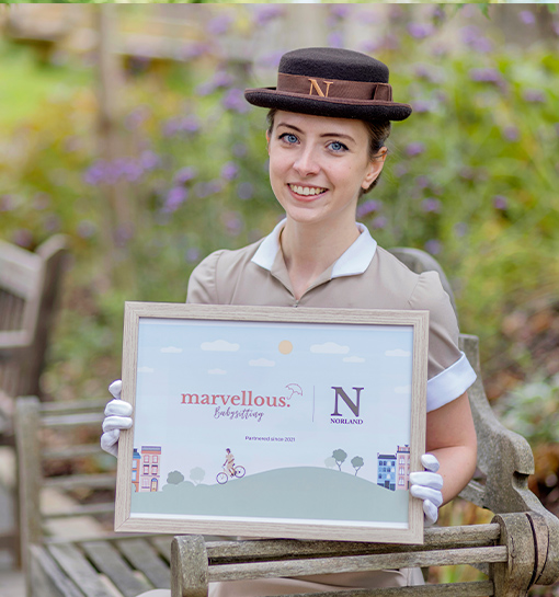 A female in a Norland uniform holding a sign about babysitting