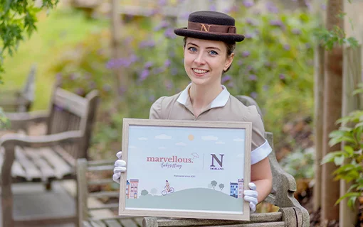 A female in a Norland uniform holding a sign about babysitting