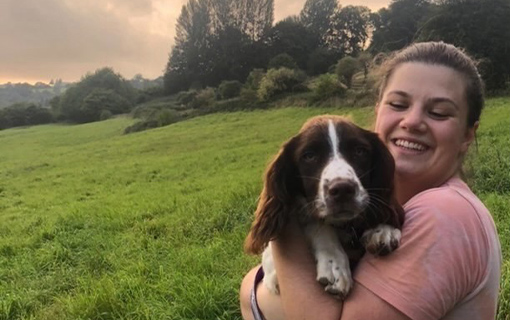 Marie, an international student studying at Norland. with a dog in a field