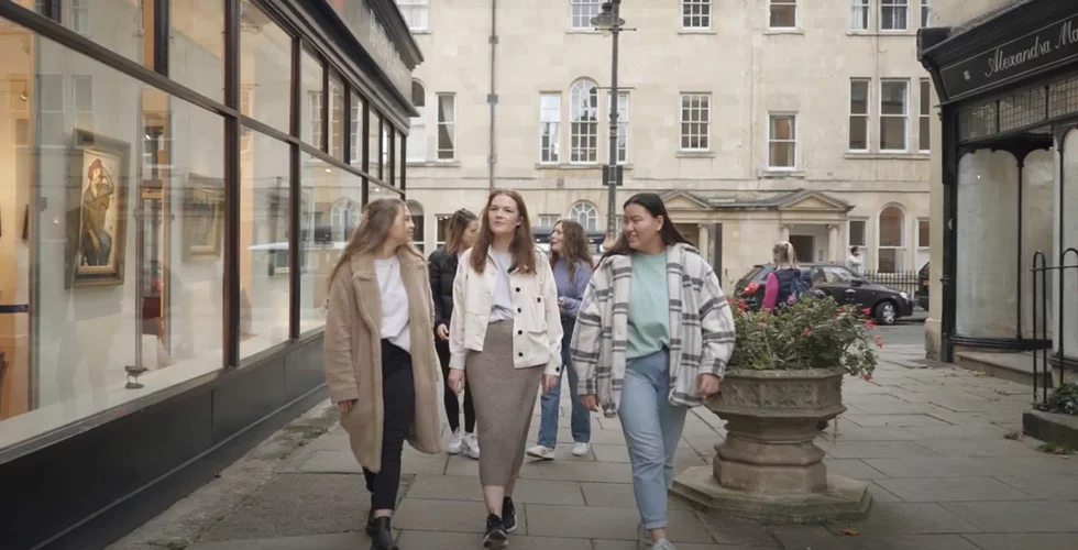a group of students walking down a street in Bath
