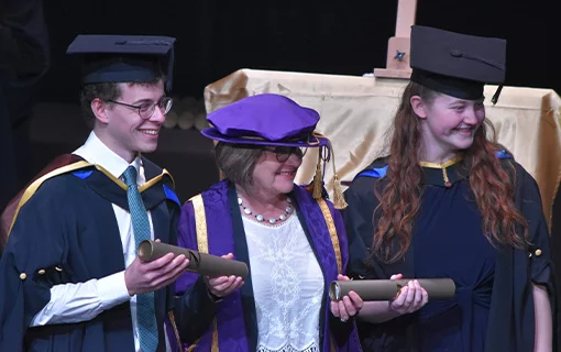 two graduates smiling