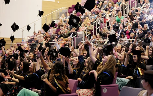 graduates throwing their mortar boards in the air