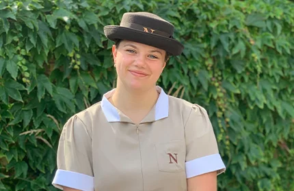 a female nanny in uniform smiling