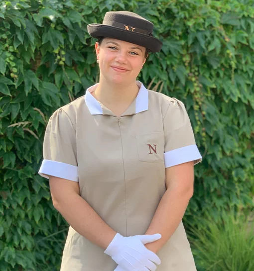 a female nanny in uniform smiling