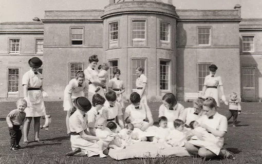 a black and white photo of Norland Nannies playing with children