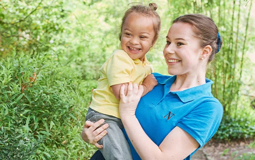 a nanny holding a child smiling