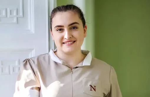 a female Norland Nanny student holding a folder