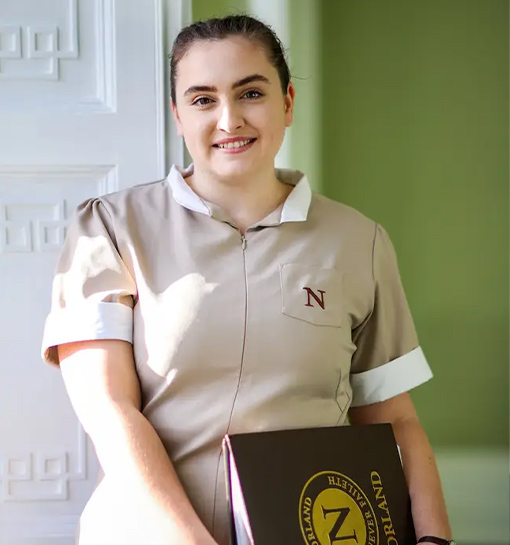 a female Norland Nanny student holding a folder