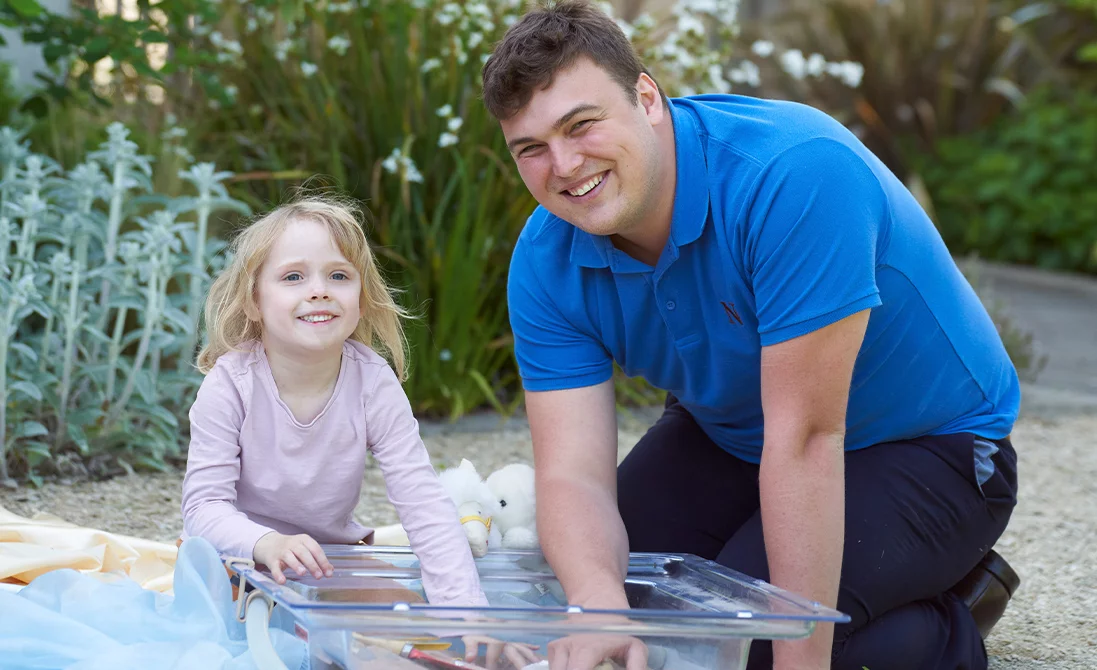 a male Norland Nanny student playing with a child