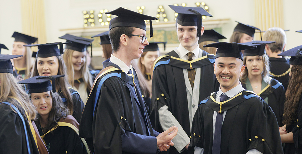 Male Norland graduates smile at their graduation in Bath