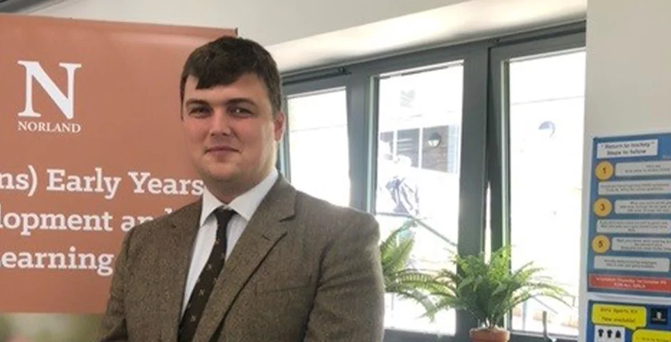 A male student training to become a Norland Nanny at a careers fair at Beechen Cliff School in Bath.