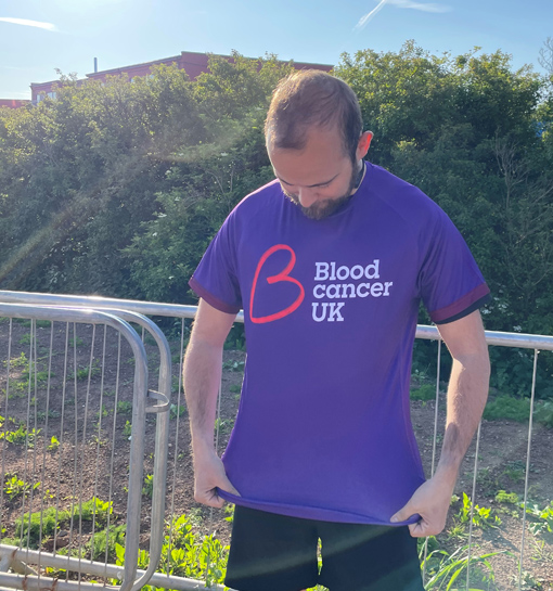 A male in running attire wearing a Blood Cancer UK shirt