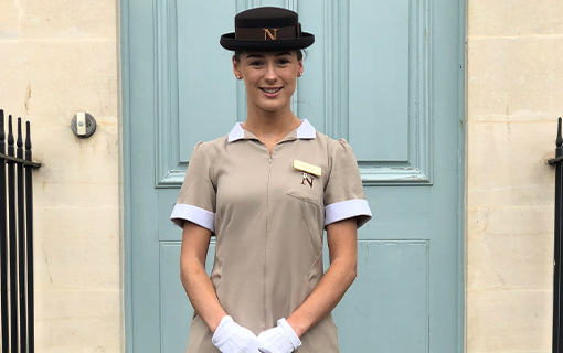 A female Norland Nany smiling in her formal uniform.