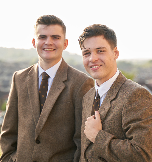 Two male Norland Nanny students in their formal uniform