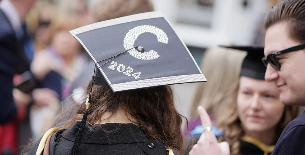 A degree graduate wearing a personalised mortar board
