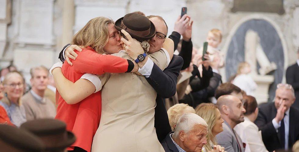 A Norland Nanny hugging her parents at her graduation