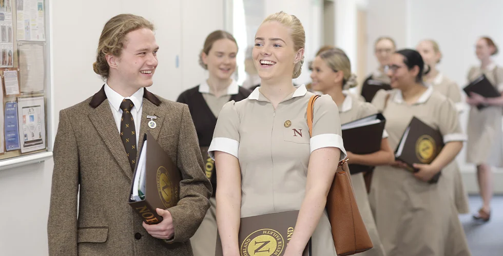 A male and female Norland Nanny student walking down a corridor
