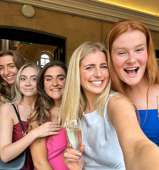 Norland students in formal dresses taking a smiling selfie