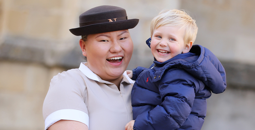 Norland Nanny in formal uniform holding smiling baby