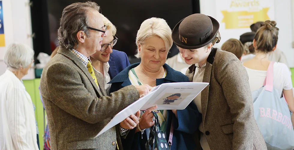 Parents and student looking at book