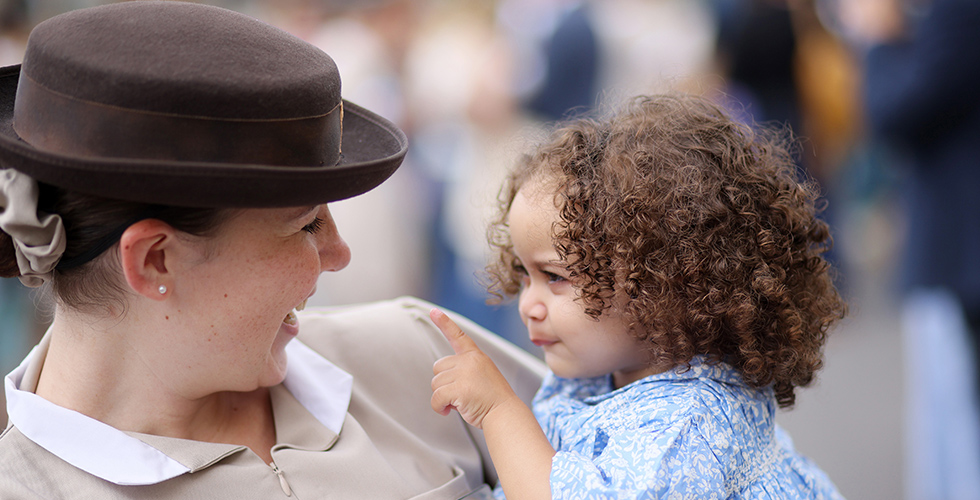 Norland student smiling and holding baby