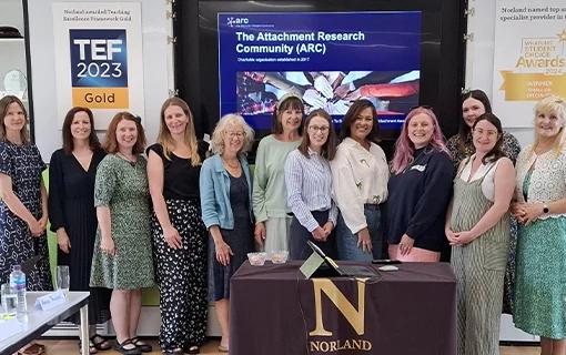 A group of people from the Attachment Research Community stood in front of a screen