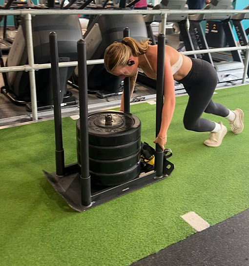 A student pushing some weights in a gym