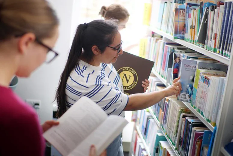 Some students in a library looking at books